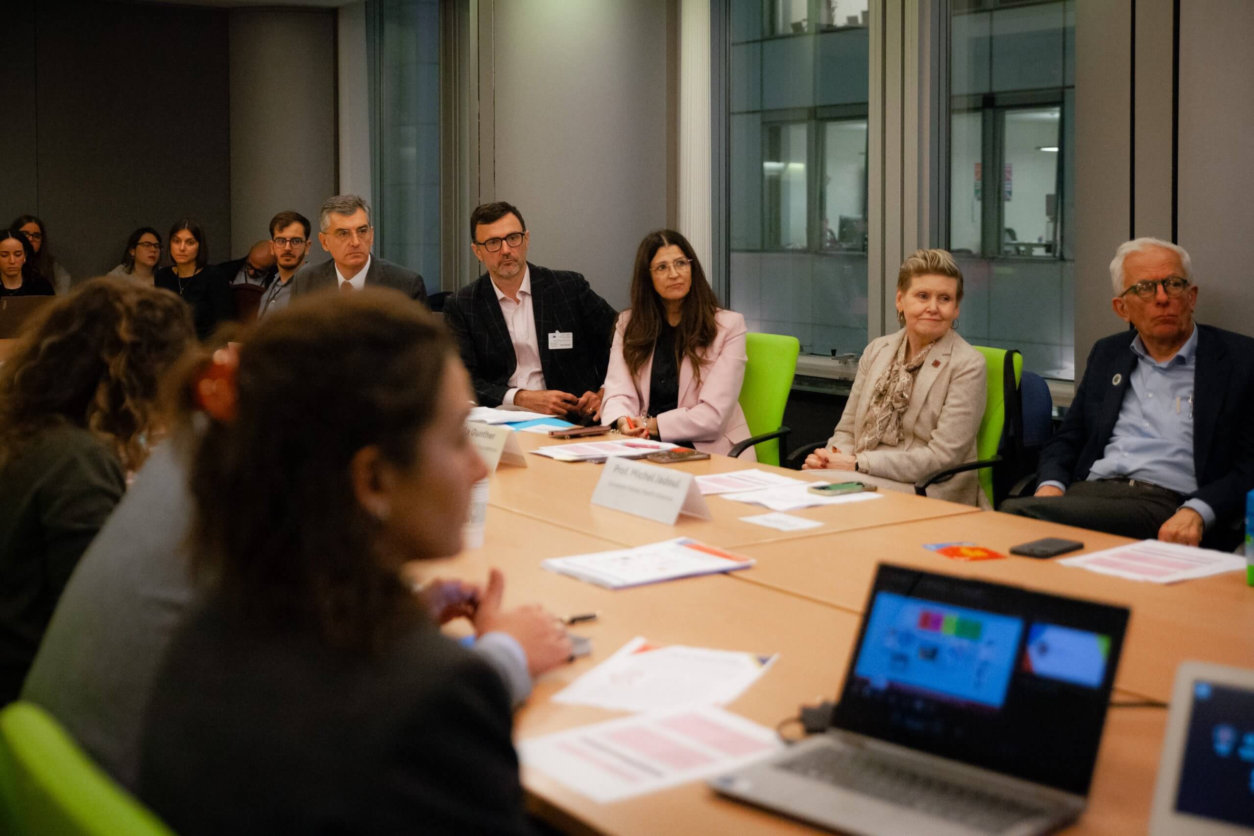 Photo from event of people gathered around a long table (boardroom setting), from the high-level panel discussion hosted in the European Parliament by MEP Romana Jerković, as part of HFPN's European Heart Failure Mission.